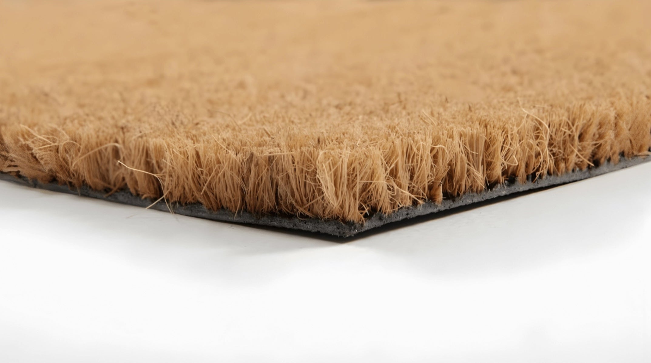 Close-up of a doormat with coir fibers on a white background
